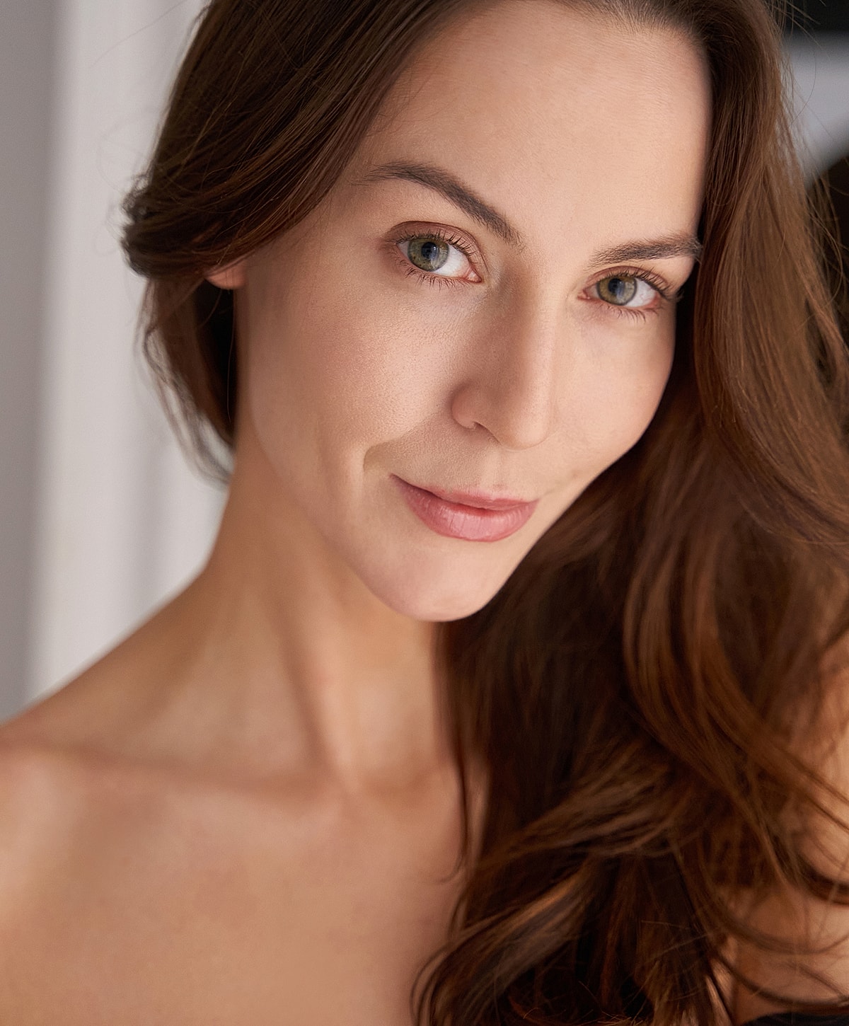 Melbourne facial implant model with long hair and captivating gaze.