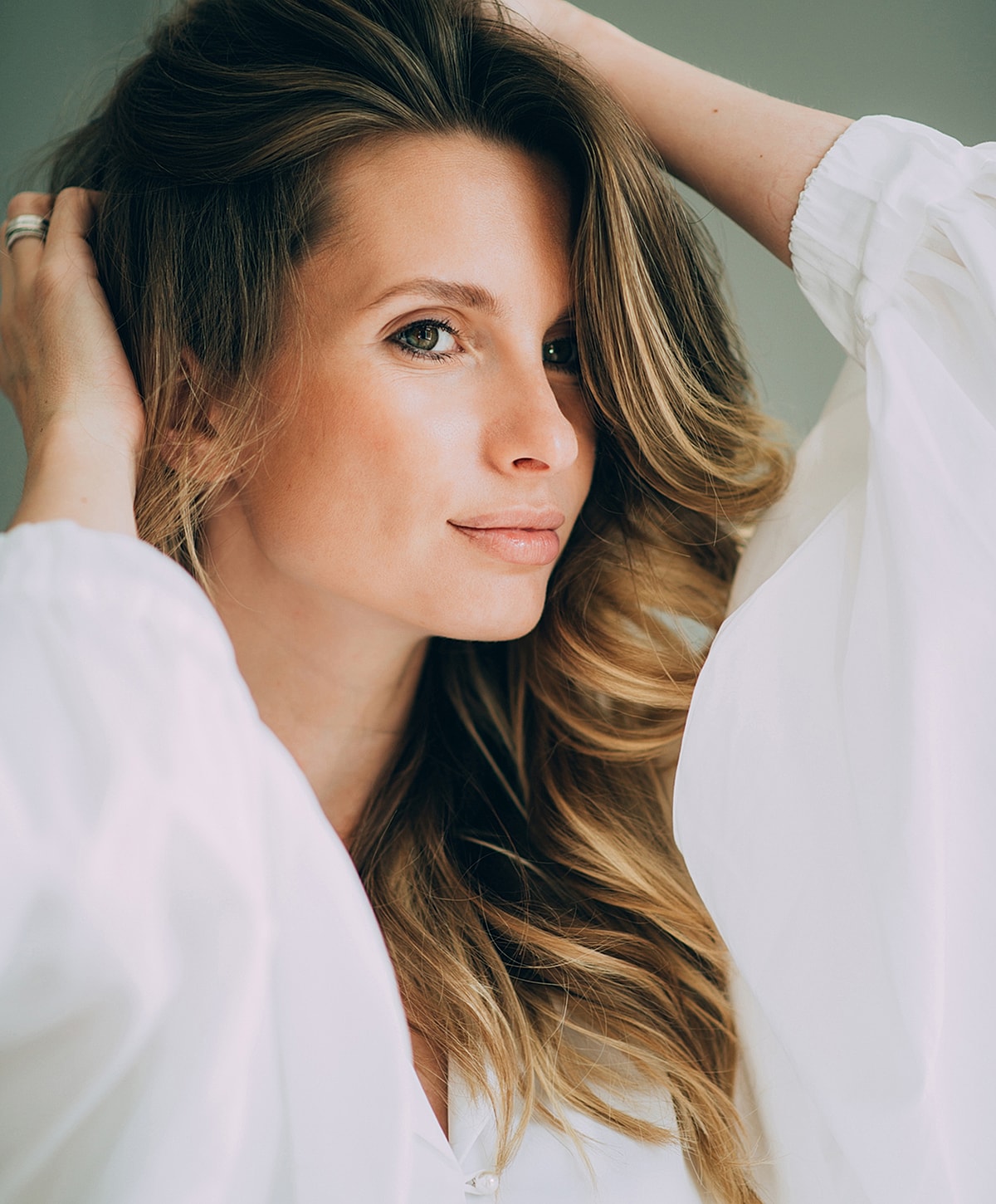 Melbourne blepharoplasty model with long hair in white blouse.