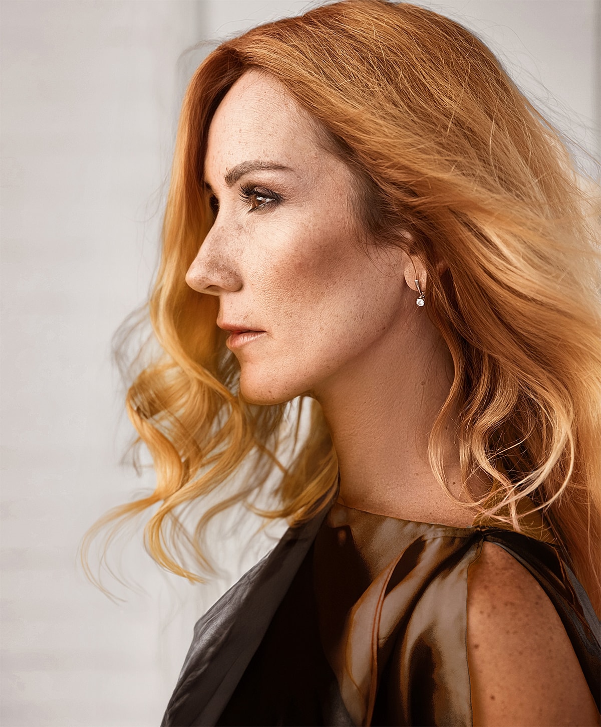 Melbourne facelift model with long, wavy red hair in profile.