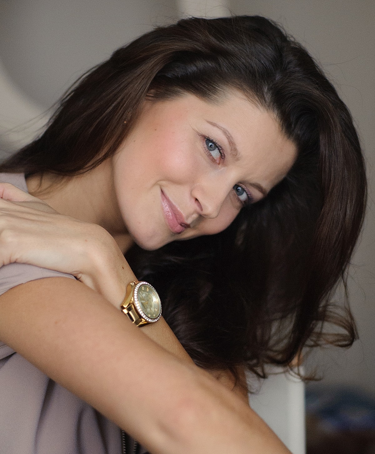 Melbourne deep plane facelift model smiling with long dark hair and watch.