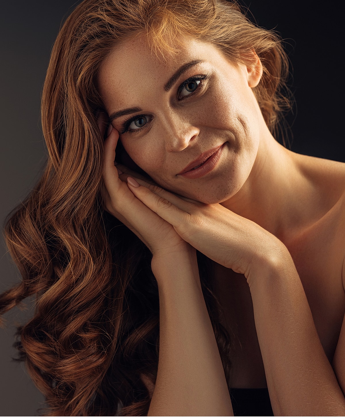 Smiling Melbourne scar revision model with long, wavy, red hair.