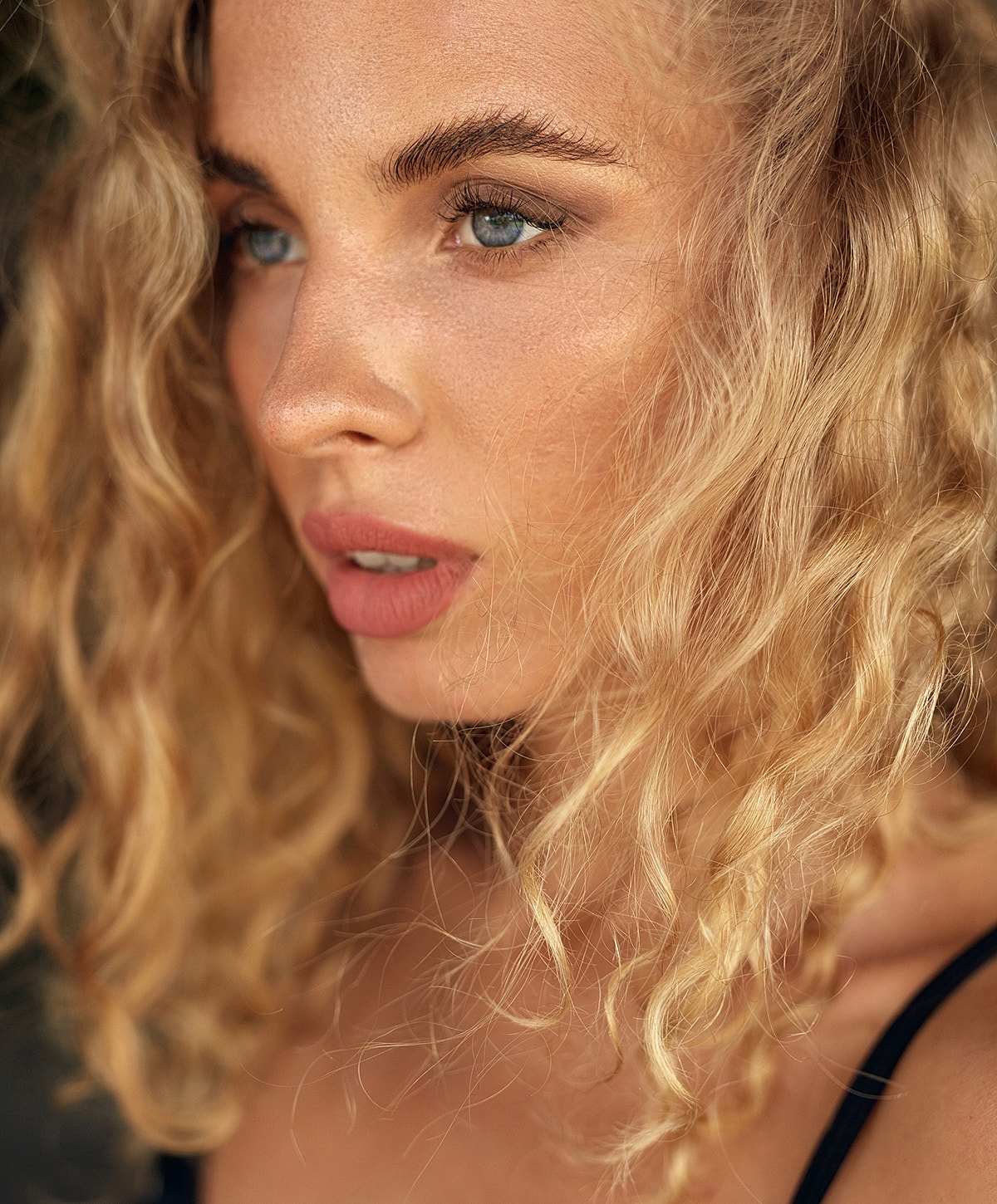 Close-up of a Melbourne dermal filler model with curly blonde hair.