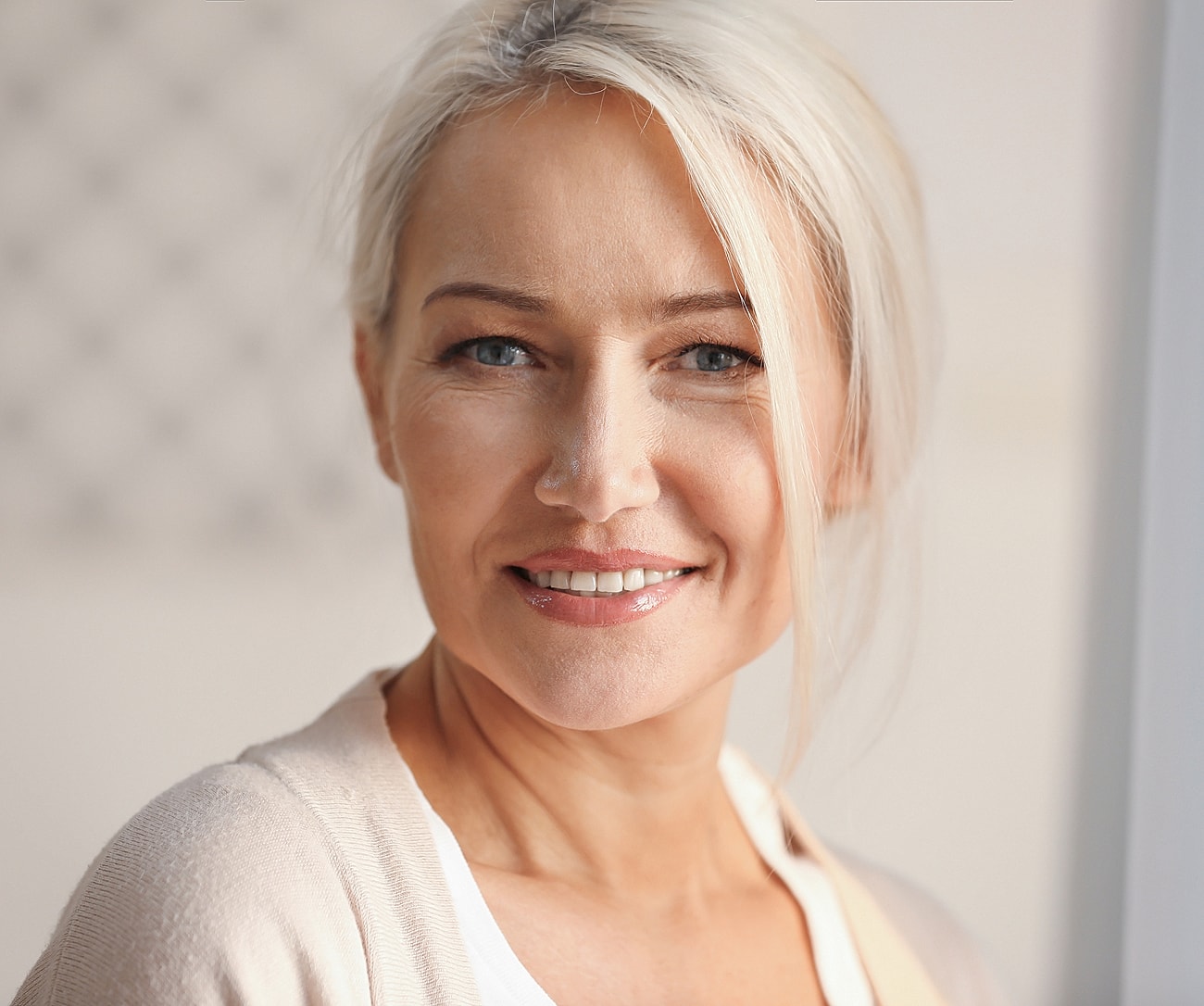 Smiling middle-aged Melbourne facial cosmetic surgery model with blonde hair.