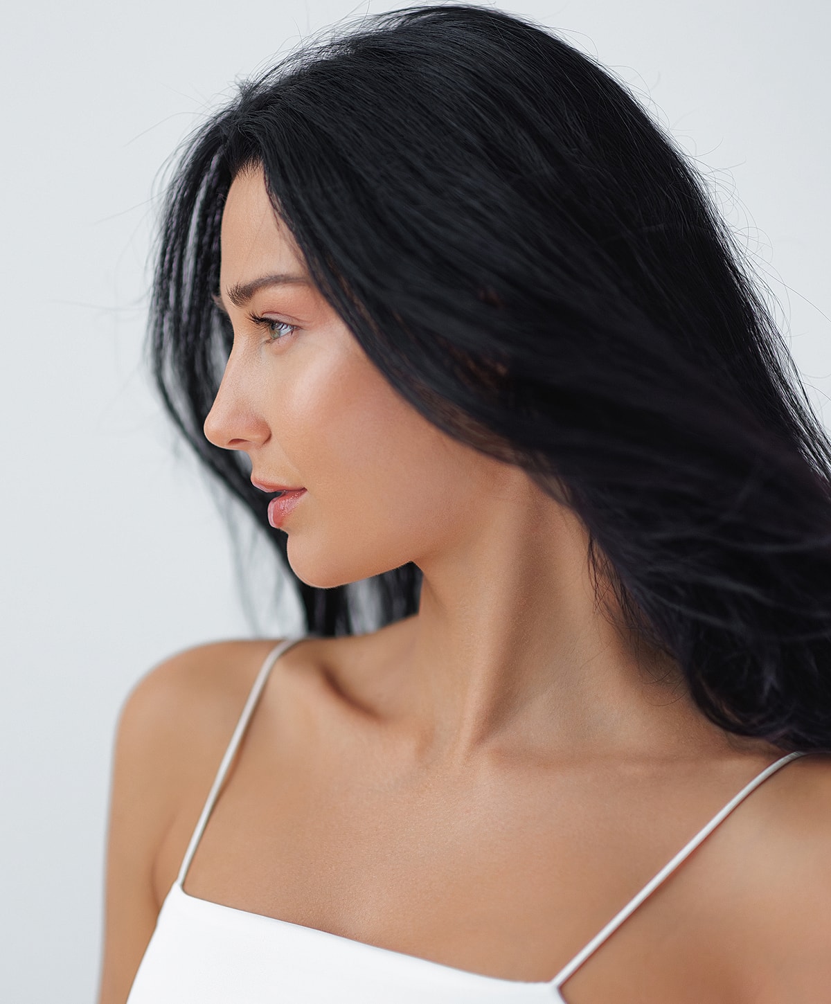 Melbourne medical-grade skincare model with long black hair in profile.