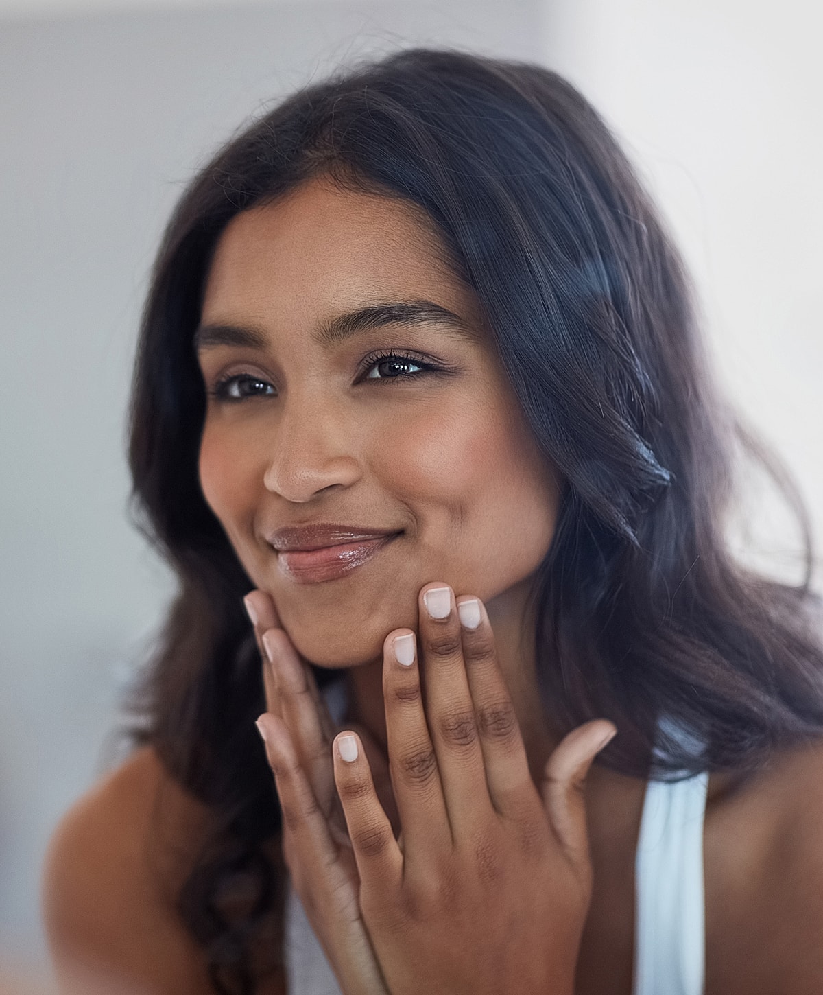 Smiling Melbourne chemical peel model with hands on her face.