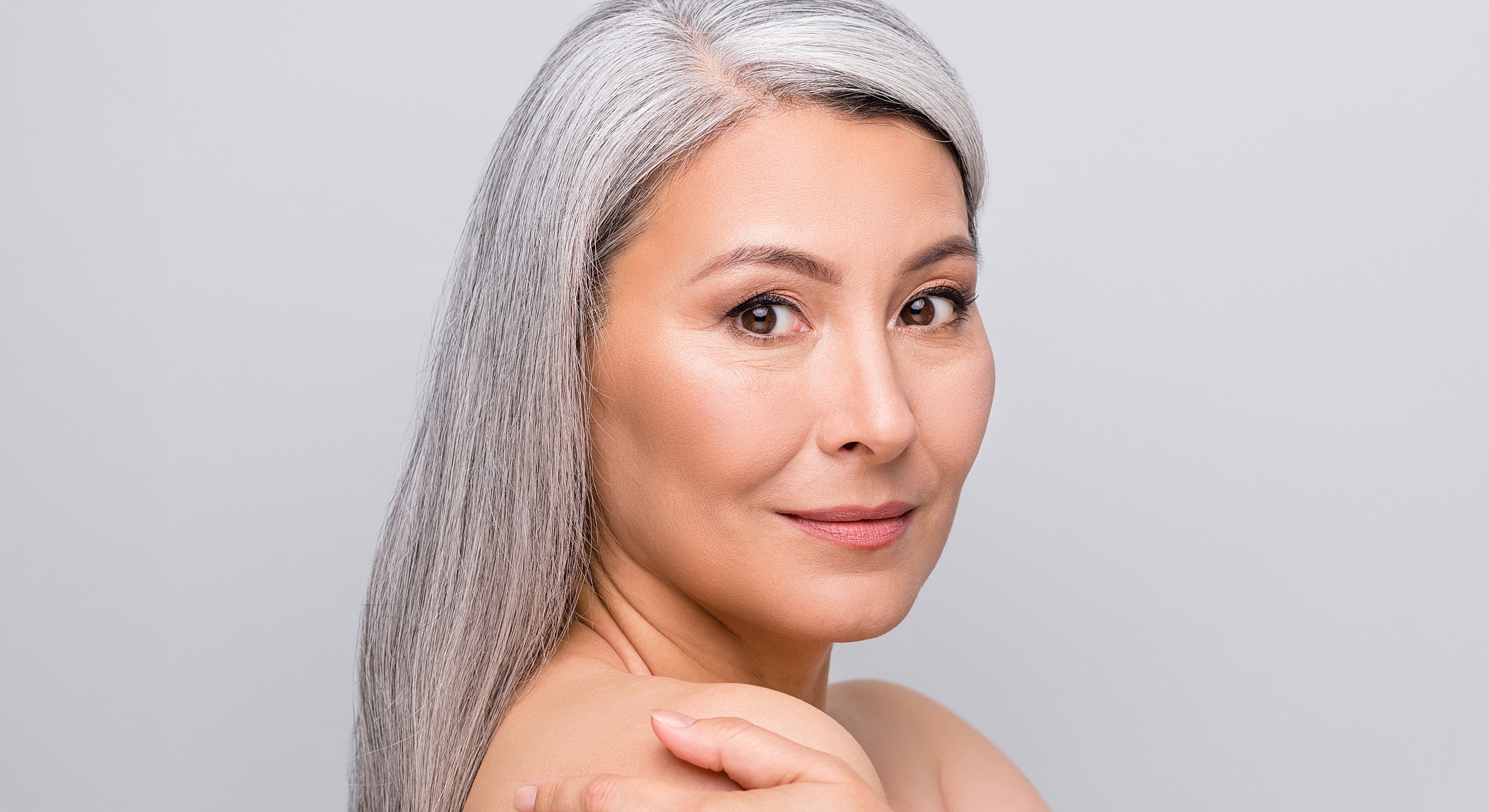 Melbourne facelift model with long gray hair smiling softly.