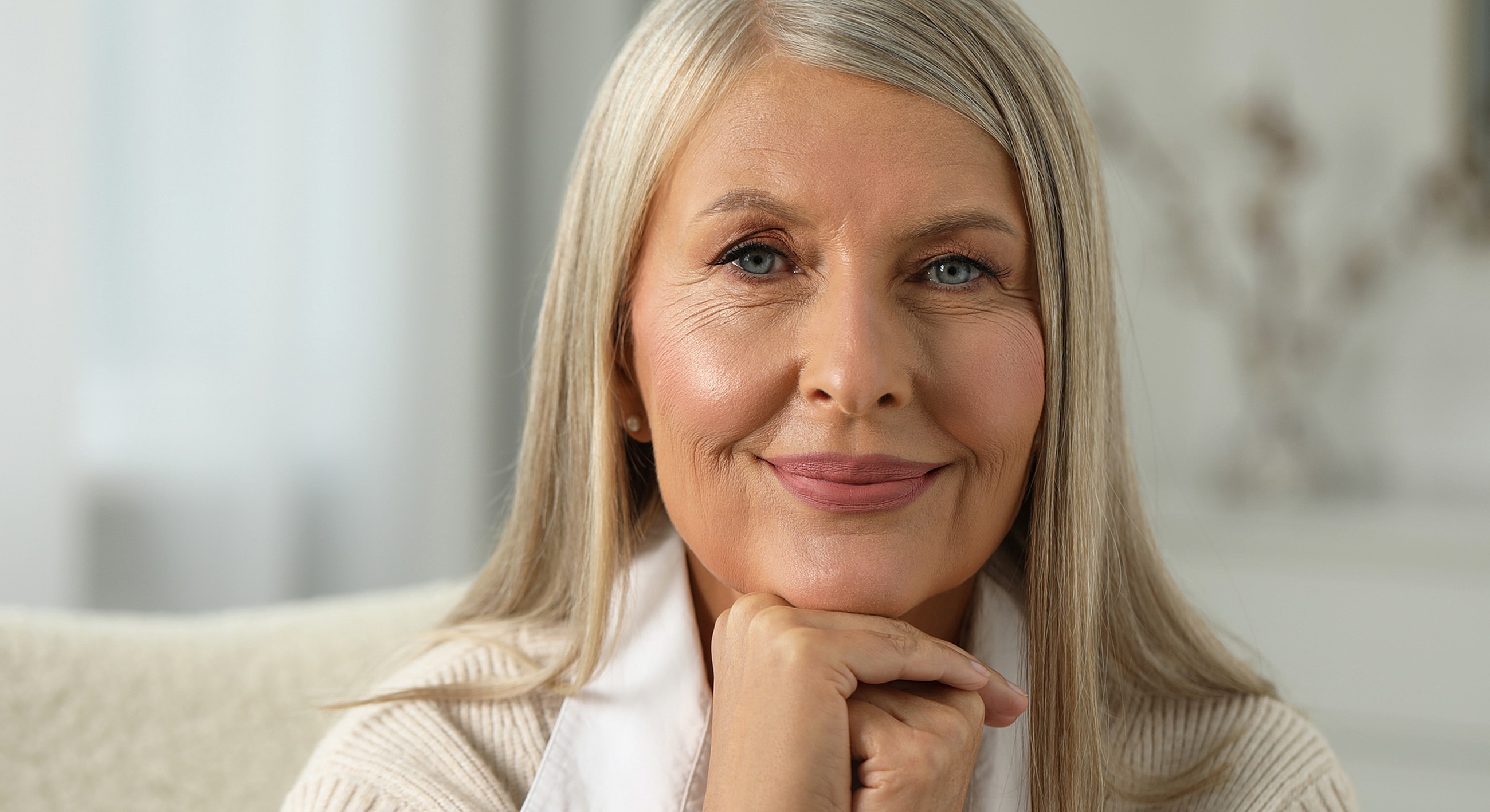 Smiling Melbourne deep plane facelift model with gray hair indoors.