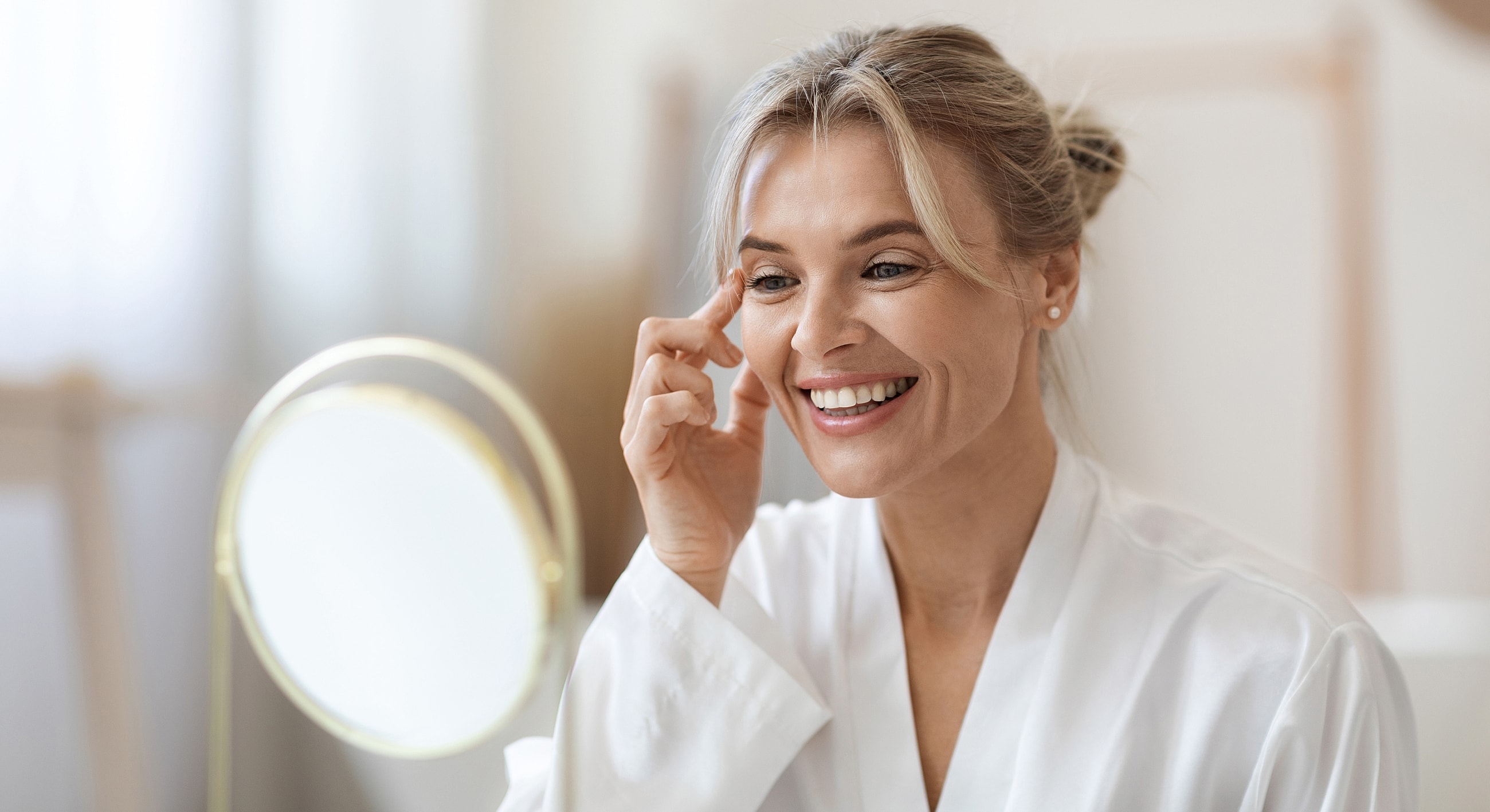 Melbourne medical-grade skincare model applying skincare in front of mirror.