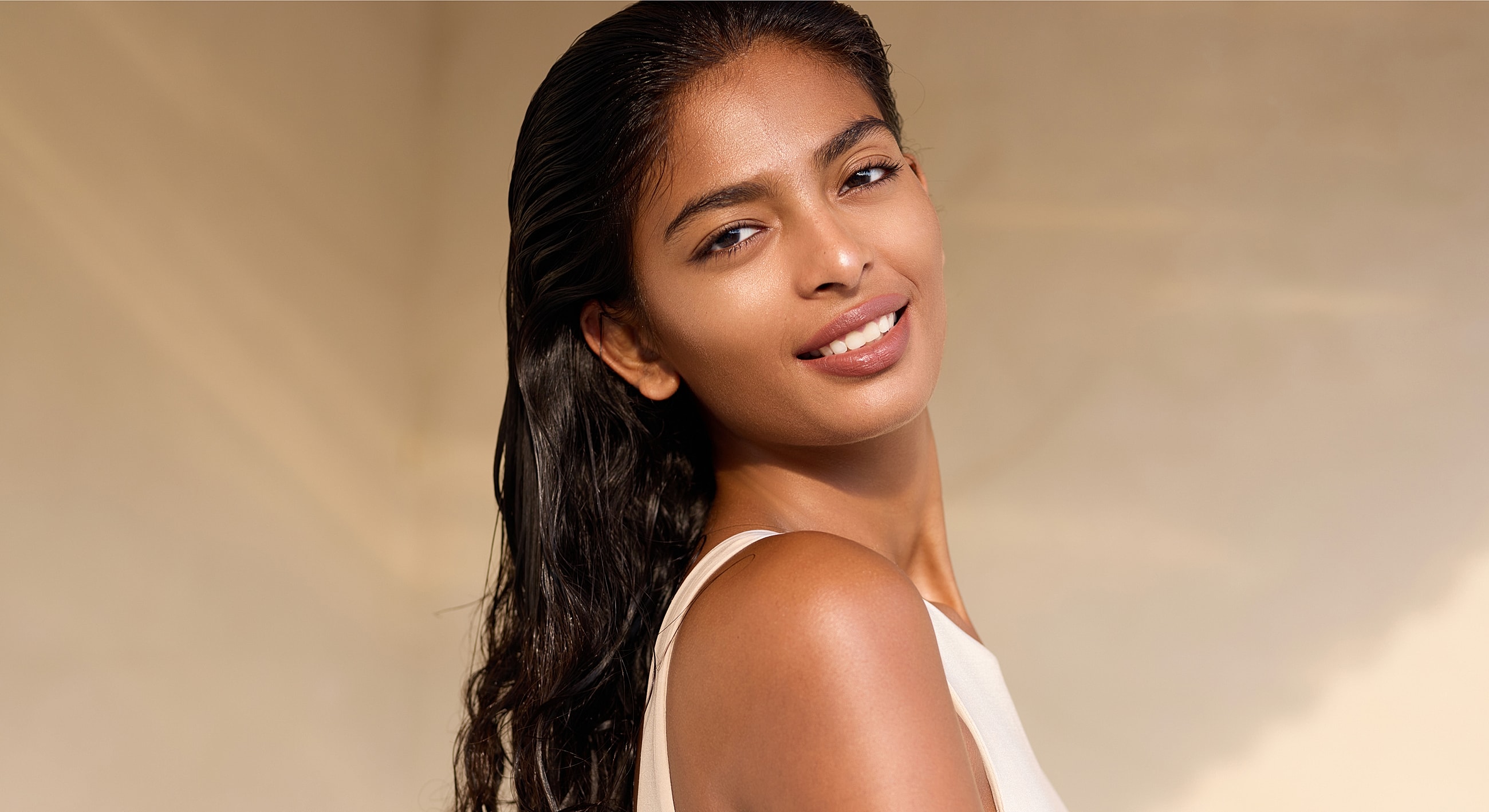 Smiling Melbourne Hydrafacial model with long, dark hair.